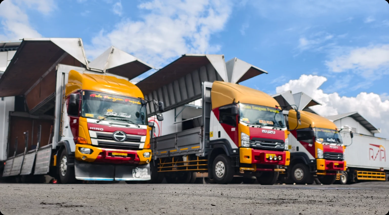 Truk wingbox RAPI dengan sisi bak terbuka